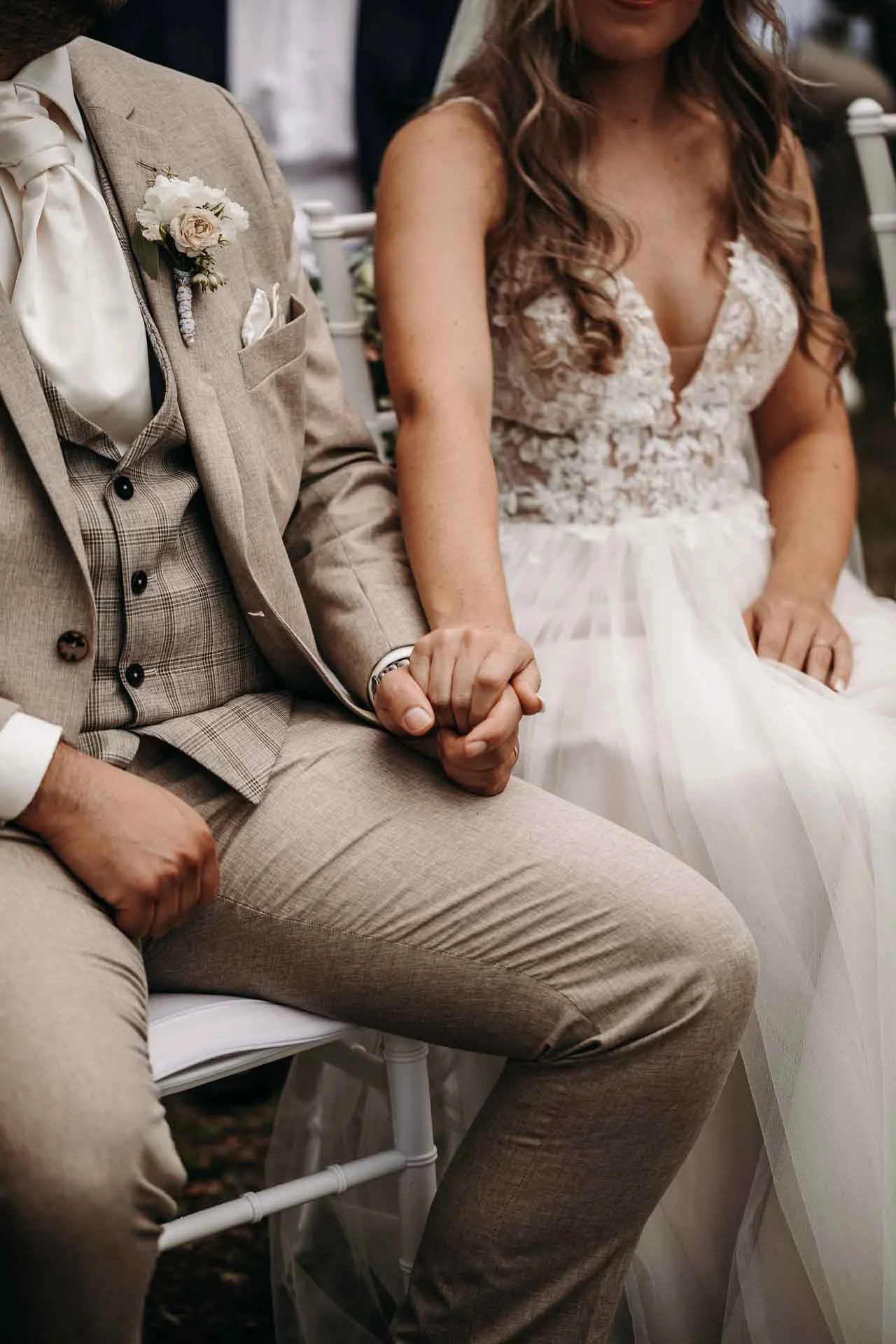 Ein Hochzeitspaar hält während der Trauung fest die Hände