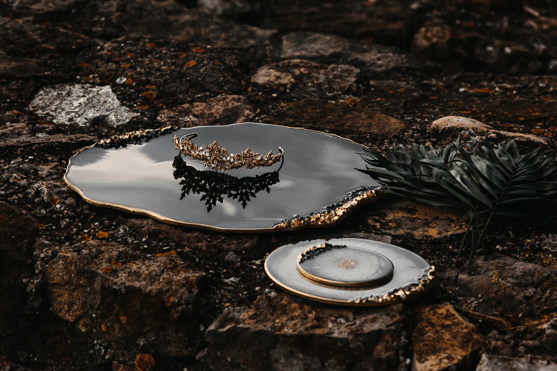 Ein goldener Haarschmuck spiegelt sich auf einer dunklen Ablage