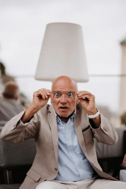 Ein Hochzeitsgast setzt eine Scherzbrille mit großen Augen auf