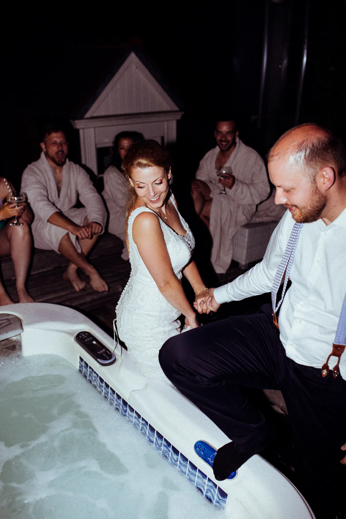 Ein Hochzeitspaar tanzt Hand in Hand am Rand eines Whirlpools