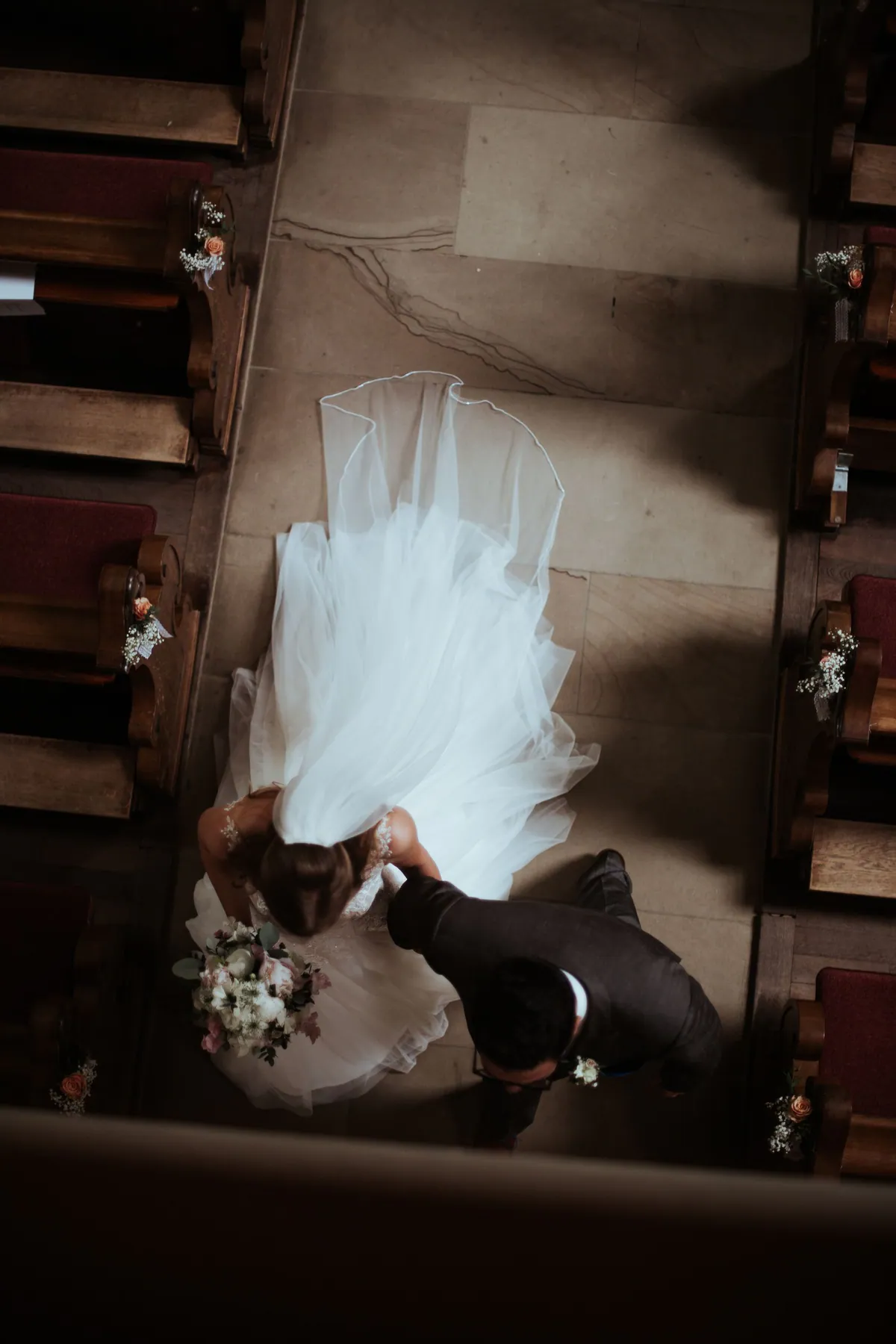 Ein Hochzeitspaar küsst sich während der kirchlichen Trauung von oben gesehen