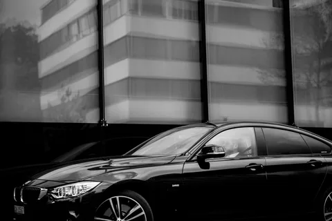 Schwarze Limousine steht vor einer modernen Gebäudefassade
