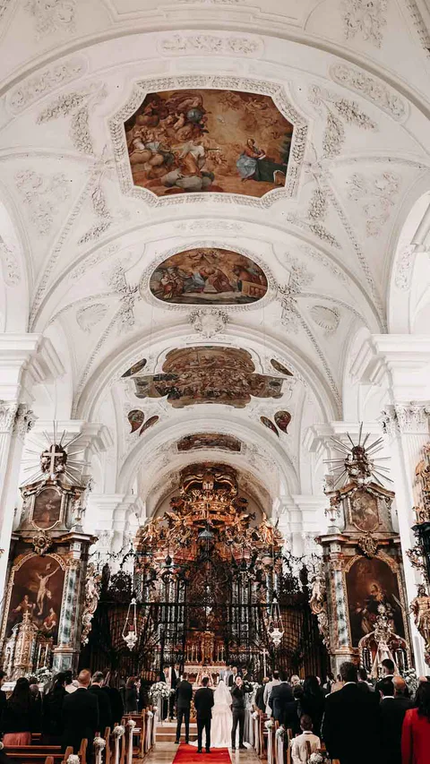 Blick durch das Kirchenschiff auf eine Trauung am Altar